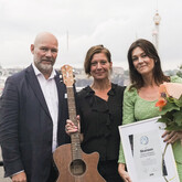 Stims vd Casper Bjørner delar ut Stimgitarren 2024 till Maria Groop Russel, vd för Skansen, och Marie Olofsson, Projektledare på evenemangsavdelningen.